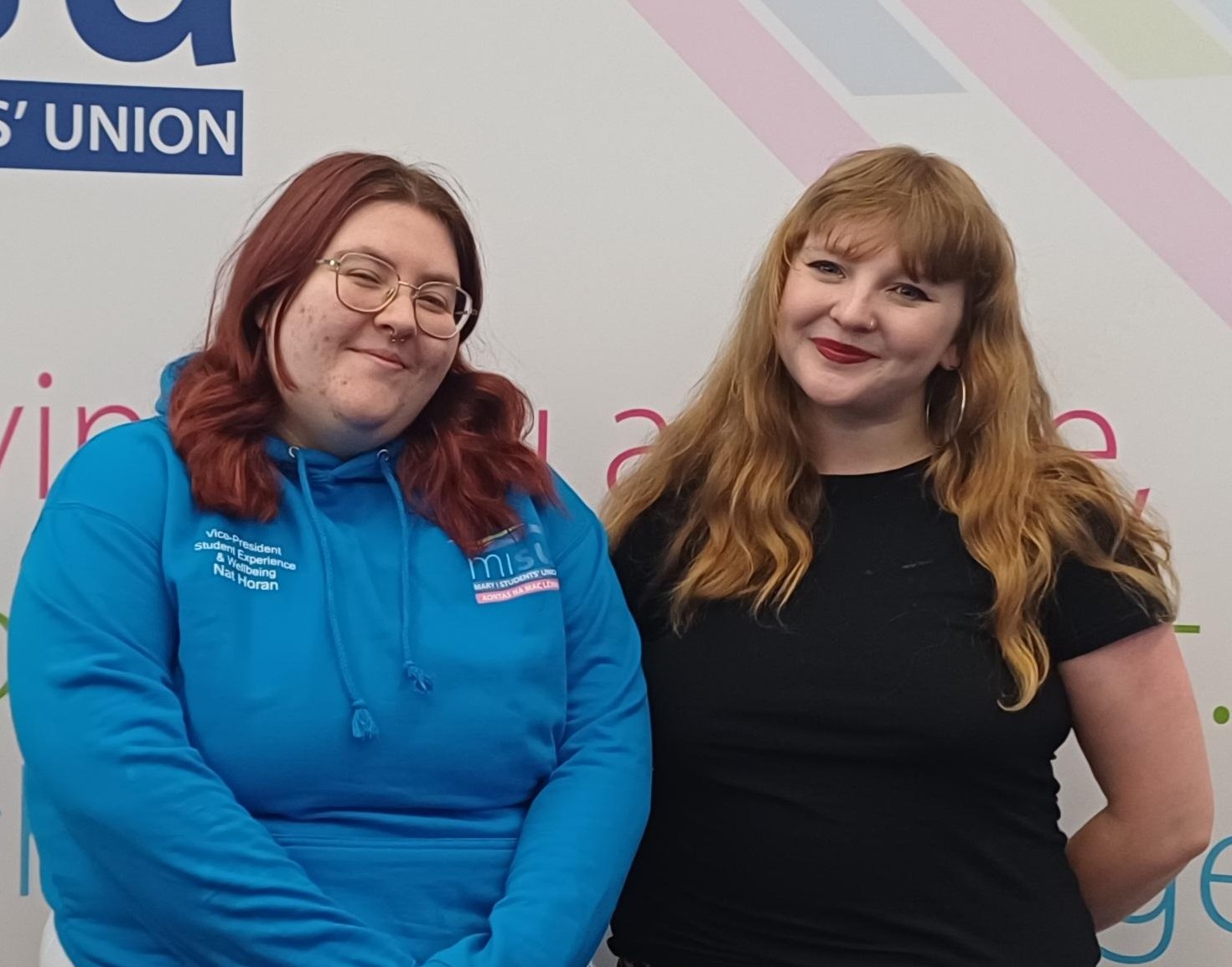 Photo of the MISU President and Vice-President Student Experience and Wellbeing facing backwards with arms linked.